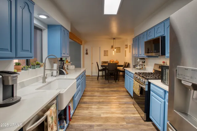 a large kitchen with stainless steel appliances microwave stove refrigerator and cabinets