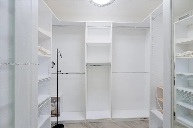 a view of walk in closet with empty racks