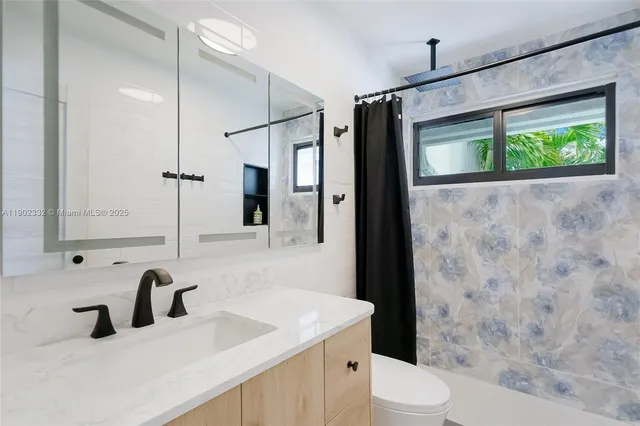 a bathroom with a granite countertop sink toilet and shower