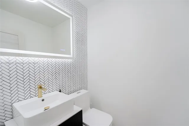 a bathroom with a sink a toilet and mirror
