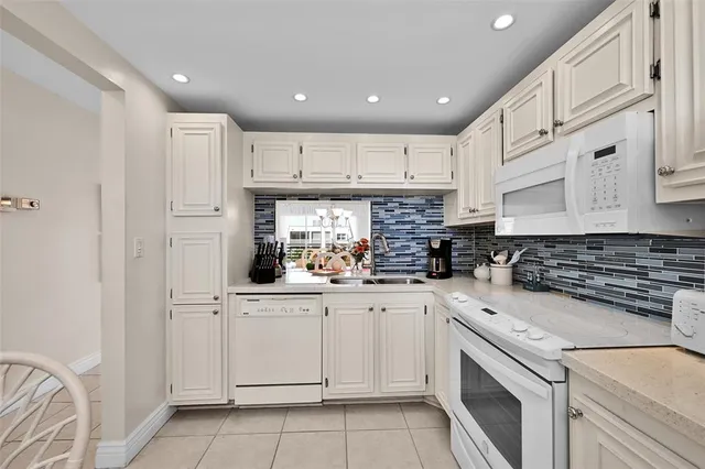 a kitchen with white cabinets and white appliances