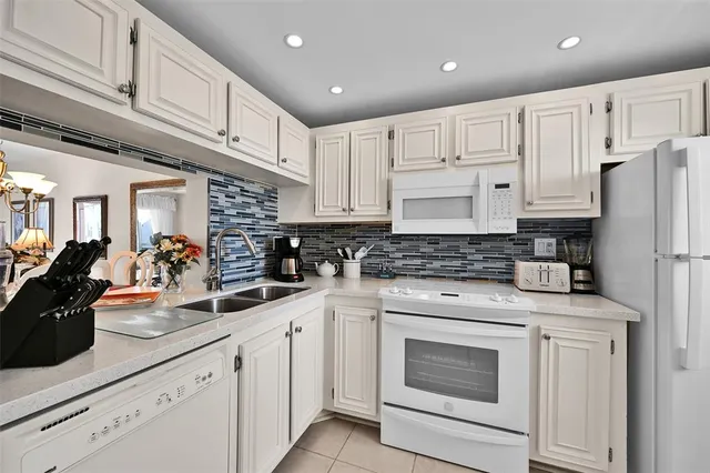 a kitchen with white cabinets and white appliances