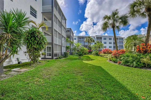 a view of a house with a big yard and palm trees