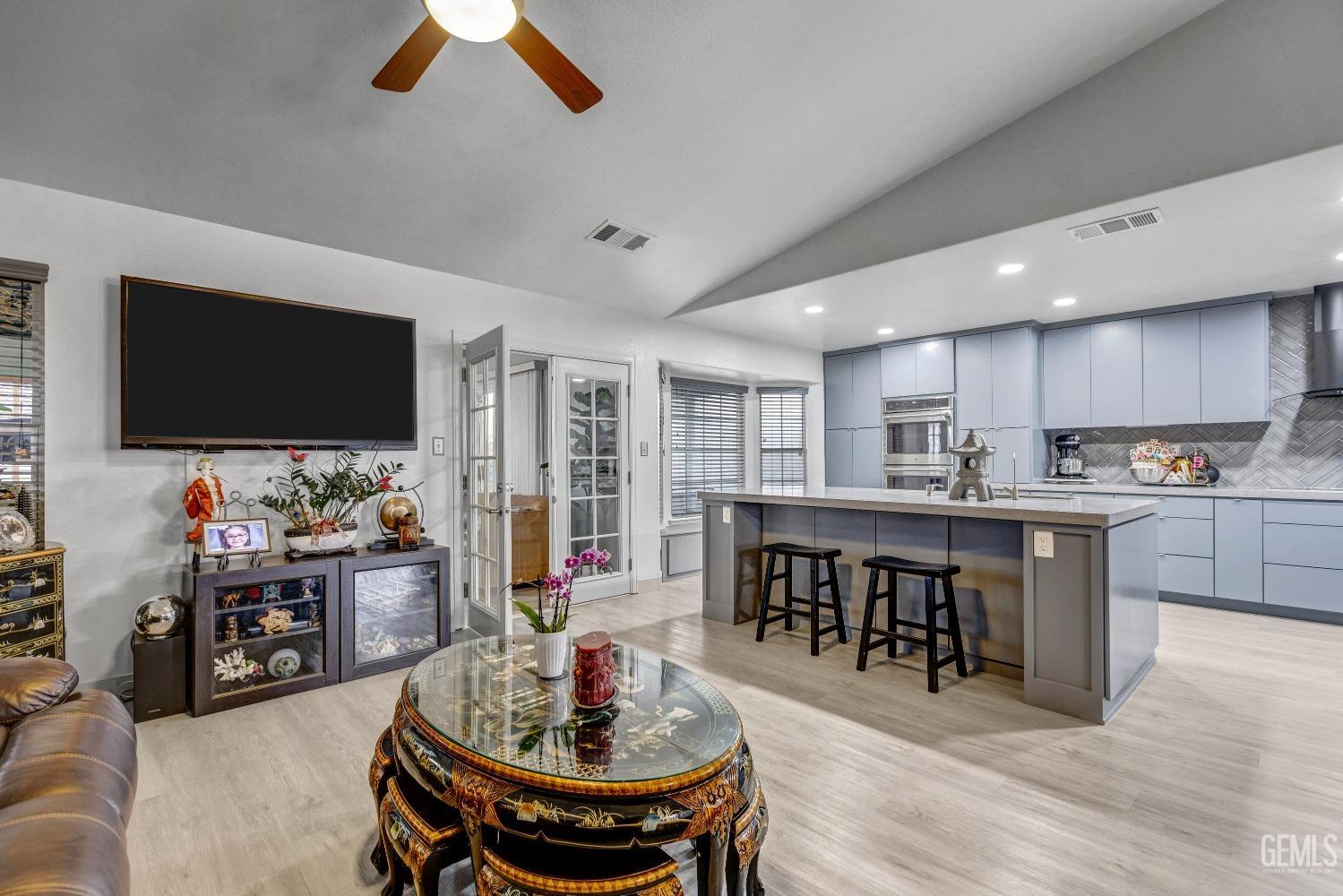 Undisclosed Address Delano, CA 93215 - Photo 9 of 40 a kitchen with stainless steel appliances kitchen island granite countertop a stove a sink a dining table and chairs with wooden floor