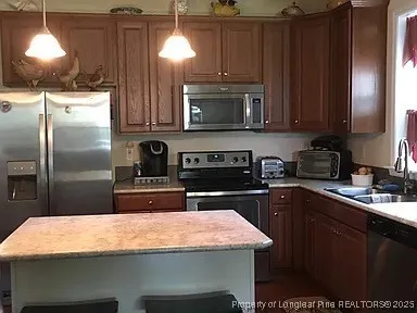 a kitchen with stainless steel appliances granite countertop a sink a stove and a refrigerator