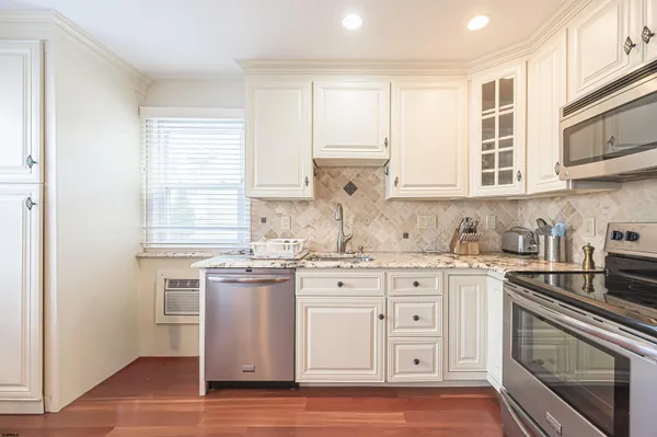 a bathroom with a granite countertop sink a toilet and a shower