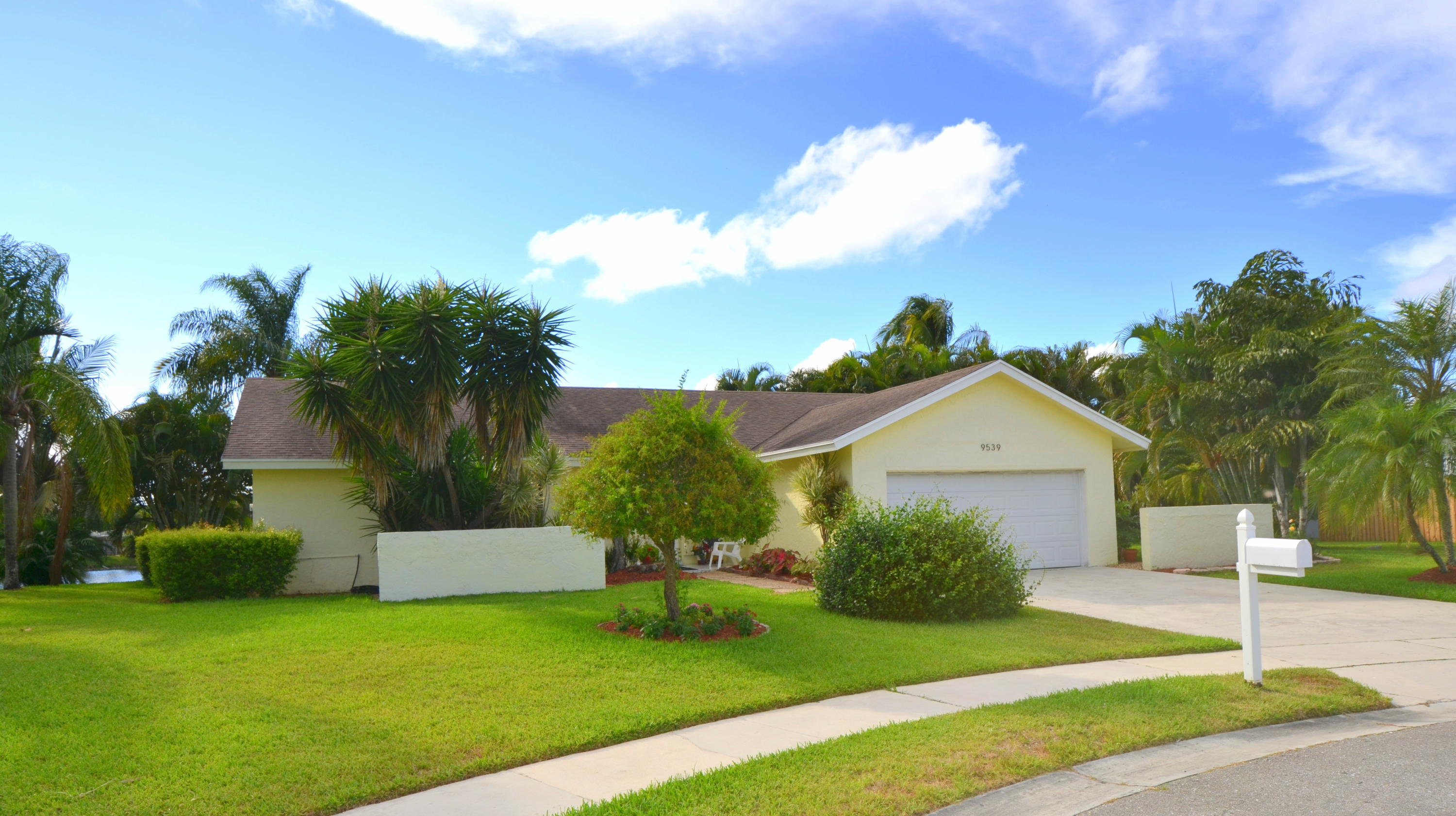 9539 Silverspring Lane Boca Raton, FL 33434 - Photo 2 of 28 a front view of a house with a yard and garage
