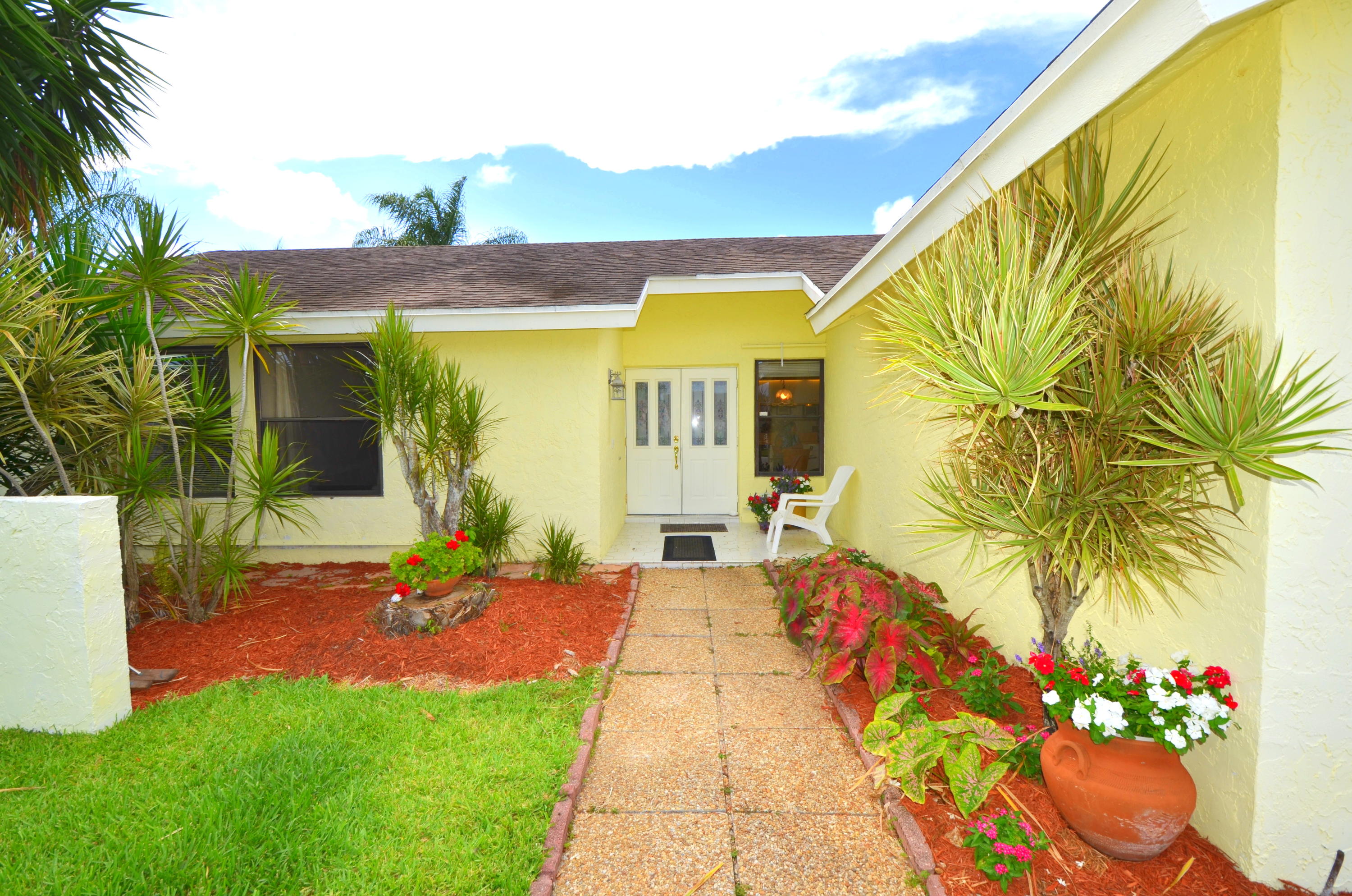 9539 Silverspring Lane Boca Raton, FL 33434 - Photo 4 of 28 a front view of a house with a yard