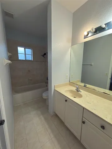 a bathroom with a granite countertop sink a toilet and bathtub