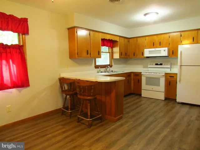 a kitchen with stainless steel appliances a sink cabinets and wooden floor
