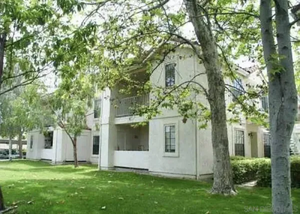 a view of a white house with a big yard and large trees