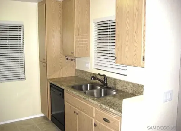 a bathroom with a granite countertop sink and a window