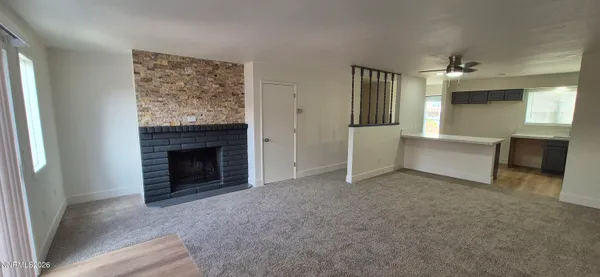 an empty room with windows and fireplace
