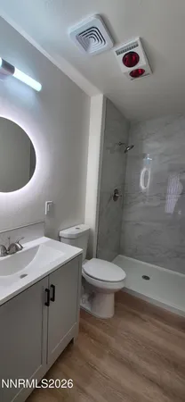 a bathroom with a sink a toilet and shower
