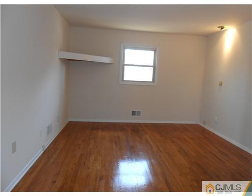 8 Nottingham Road Edison, NJ 08820 - Photo 7 of 15 an empty room with wooden floor and windows