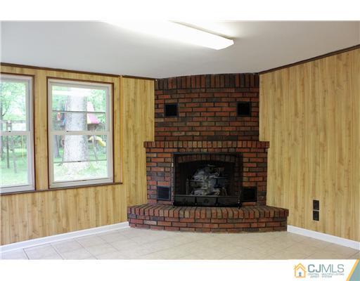8 Nottingham Road Edison, NJ 08820 - Photo 10 of 15 a living room with a fireplace and a floor to ceiling window