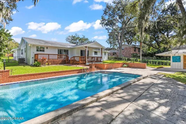 an aerial view of residential houses with outdoor space and trees all around