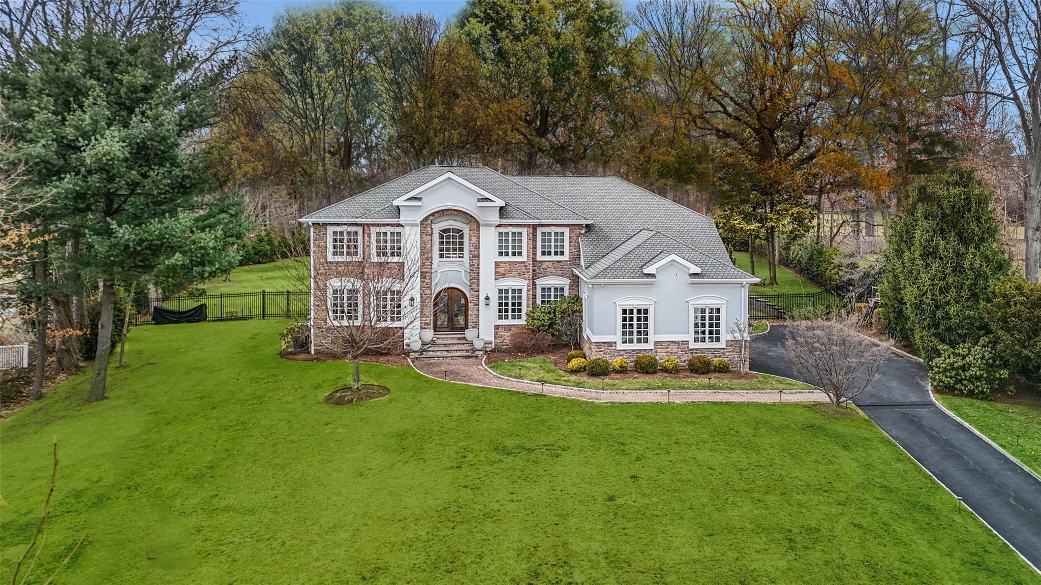 a front view of a house with a yard and trees