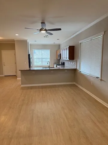 a view of a livingroom with kitchen and a window