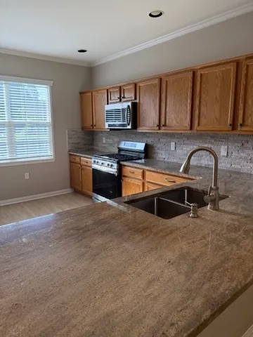 a kitchen with stainless steel appliances granite countertop a sink and a stove top oven