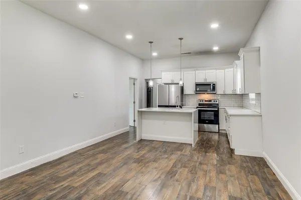 a kitchen with stainless steel appliances a refrigerator and a stove top oven