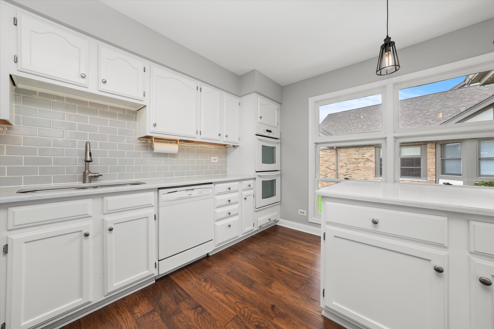 10620 Golf Road Orland Park, IL 60462 - Photo 13 of 42 a kitchen with cabinets wooden floor and a window