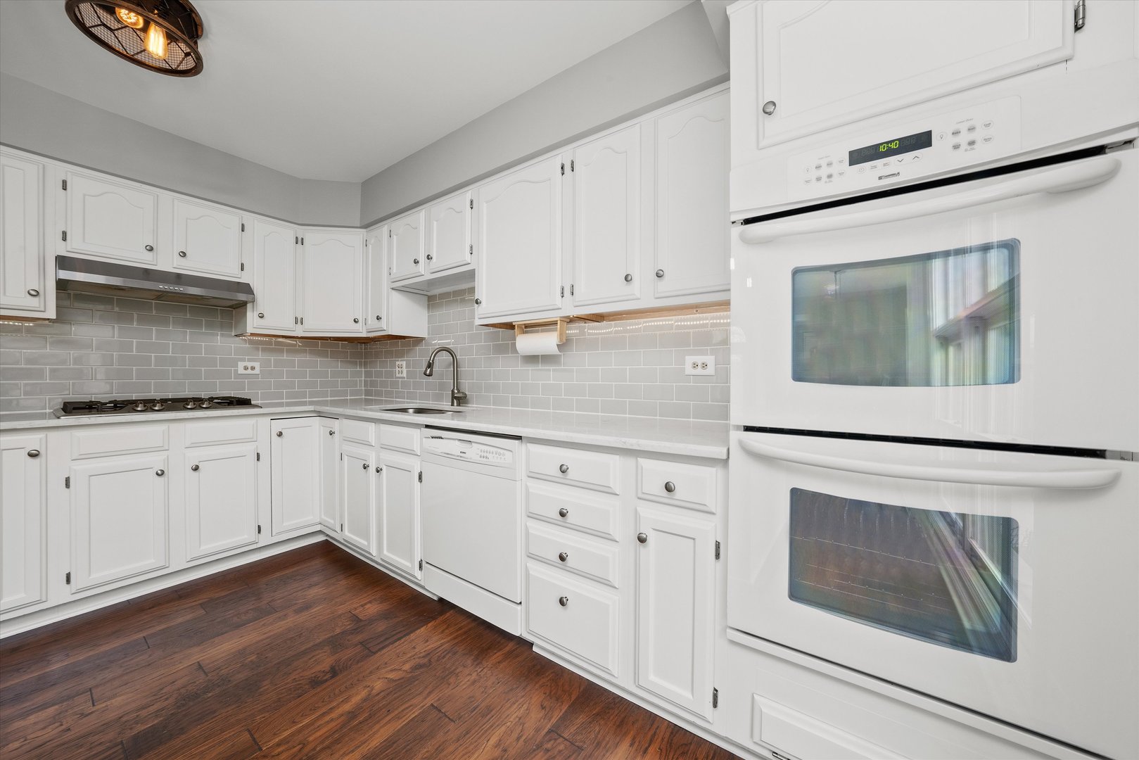 10620 Golf Road Orland Park, IL 60462 - Photo 14 of 42 a kitchen with granite countertop white cabinets and white appliances with wooden floor
