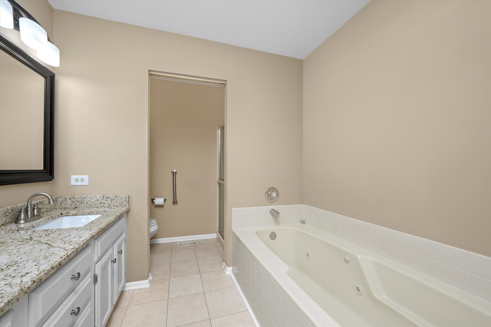 10620 Golf Road Orland Park, IL 60462 - Photo 24 of 42 a spacious bathroom with a granite countertop tub sink and mirror