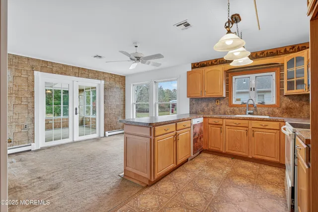 a large kitchen with kitchen island granite countertop a sink and white cabinets