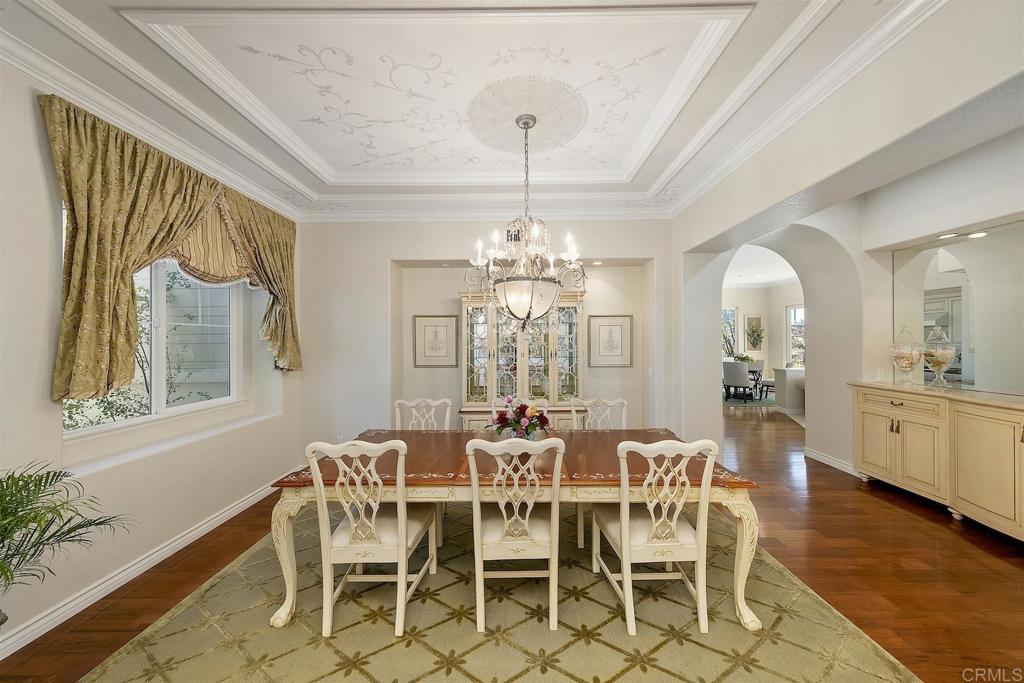1435 Ravean Court Encinitas, CA 92024 - Photo 25 of 48 a dining room with furniture a chandelier and wooden floor