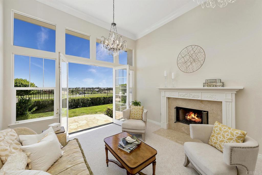 1435 Ravean Court Encinitas, CA 92024 - Photo 27 of 48 a living room with furniture a fireplace and a chandelier