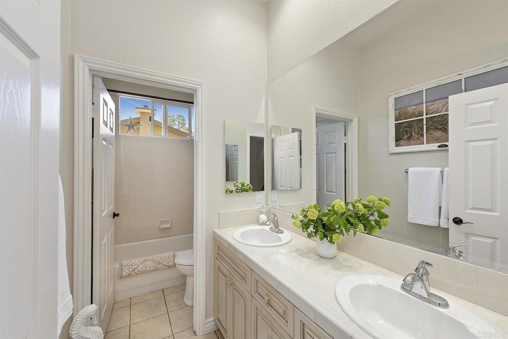 1435 Ravean Court Encinitas, CA 92024 - Photo 32 of 48 a bathroom with a granite countertop sink and a mirror