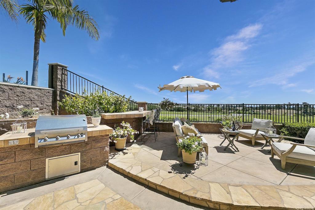1435 Ravean Court Encinitas, CA 92024 - Photo 36 of 48 a view of a patio with couches table and chairs under an umbrella with a barbeque
