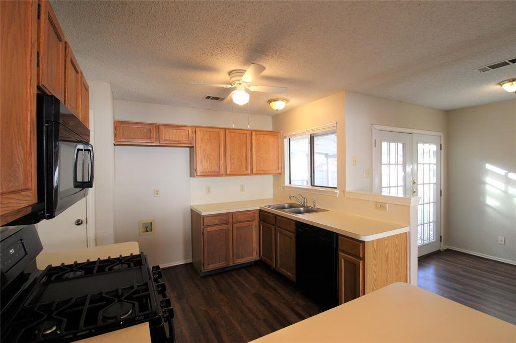 2309 Lakeshore Lane Rowlett, TX 75088 - Photo 6 of 25 a kitchen with a stove a sink and a refrigerator