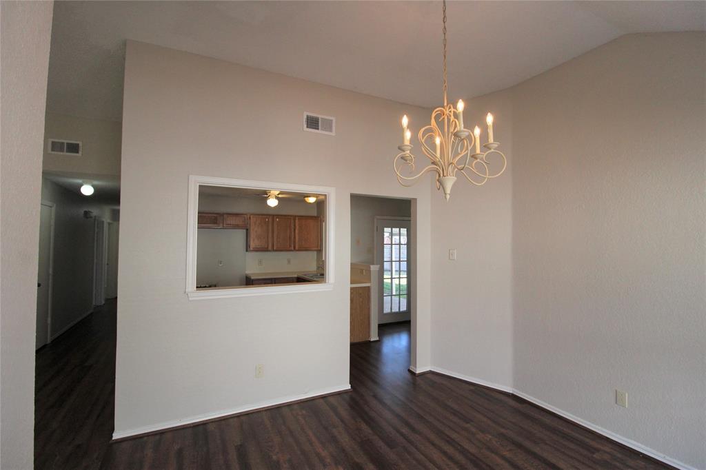 2309 Lakeshore Lane Rowlett, TX 75088 - Photo 9 of 25 a view of a hallway with wooden floor and a chandelier