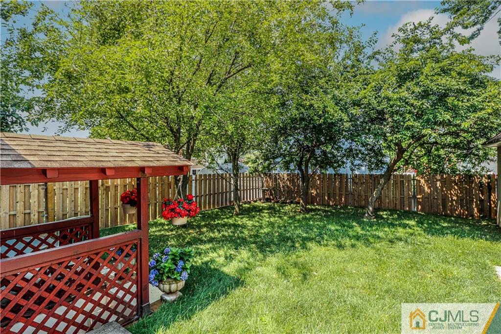 55 3rd Street Edison, NJ 08837 - Photo 23 of 27 a view of a backyard with plants and wooden fence