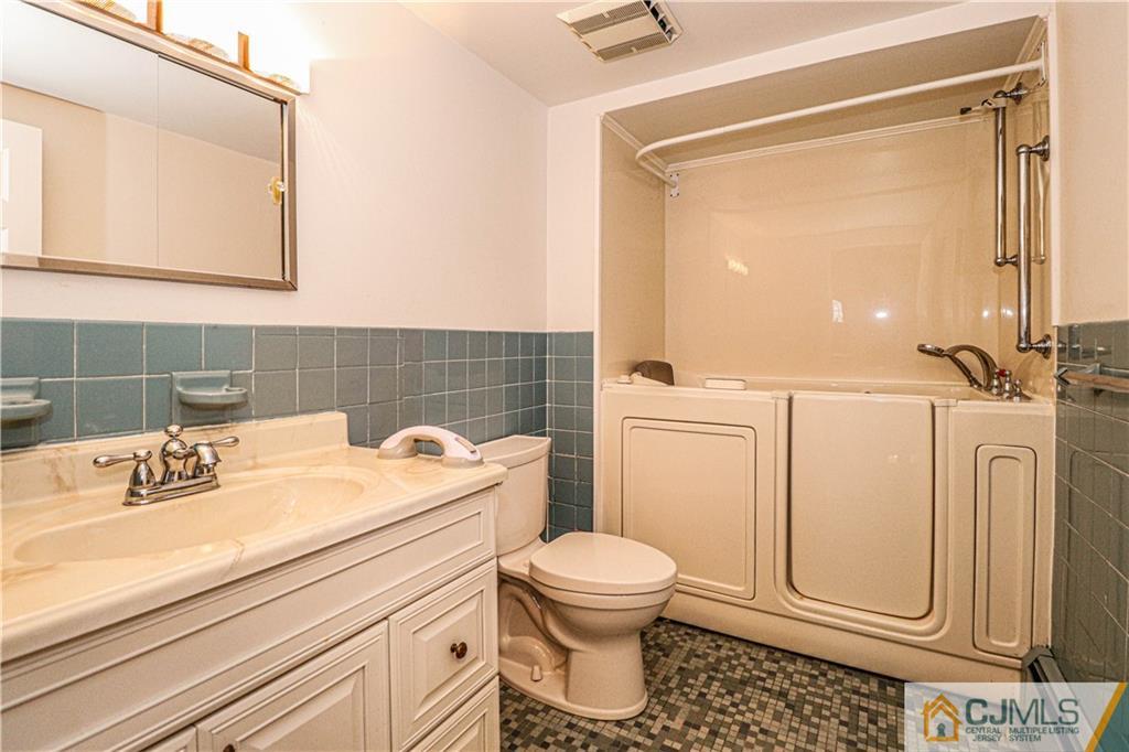 55 3rd Street Edison, NJ 08837 - Photo 9 of 27 a bathroom with a sink a toilet and a mirror