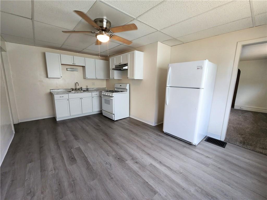 3211 Juliet Street, Unit 1 Pittsburgh, PA 15213 - Photo 2 of 8 a kitchen with stainless steel appliances a refrigerator a sink dishwasher a stove top oven a refrigerator and white cabinets with wooden floor