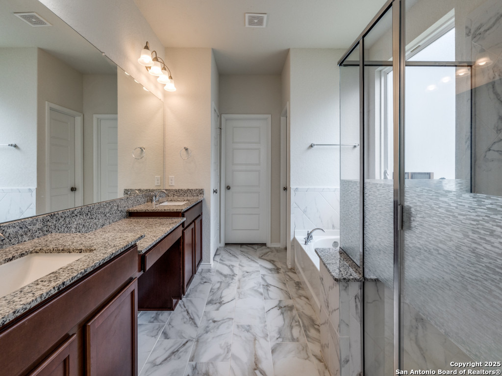 9000 Curling Post Schertz, TX 78154 - Photo 16 of 23 a spacious bathroom with a granite countertop sink and a mirror