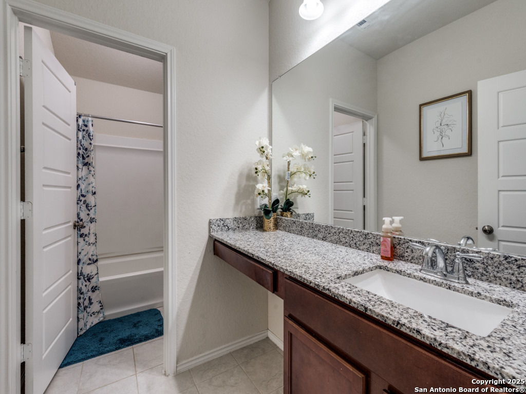 9000 Curling Post Schertz, TX 78154 - Photo 22 of 23 a bathroom with a granite countertop sink a toilet and shower
