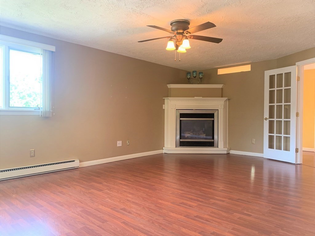 11 Hillcrest Road Salem, NH 03079 - Photo 14 of 42 an empty room with wooden floor chandelier fan and windows