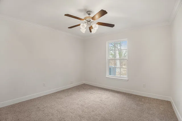 an empty room with a window and a ceiling fan