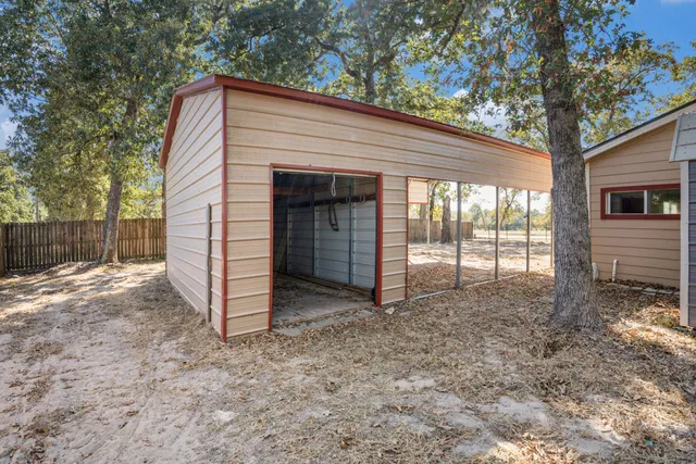 a view of house with backyard and a tree