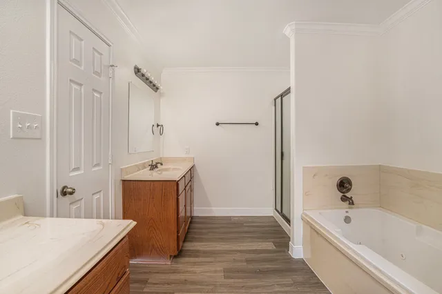 a view of a bathroom with bathtub wooden floor and windows