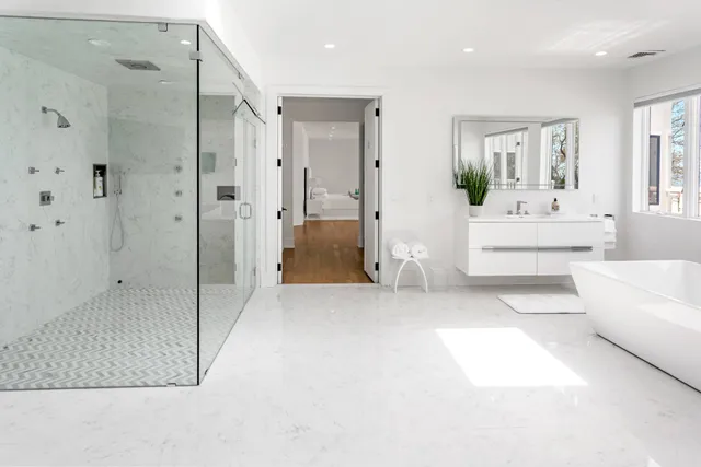 a spacious bathroom with a tub shower and mirror