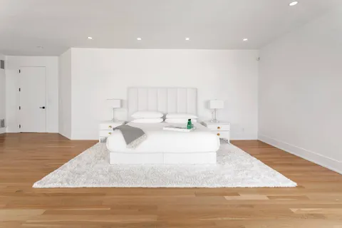 a large white room with kitchen island sink and refrigerator