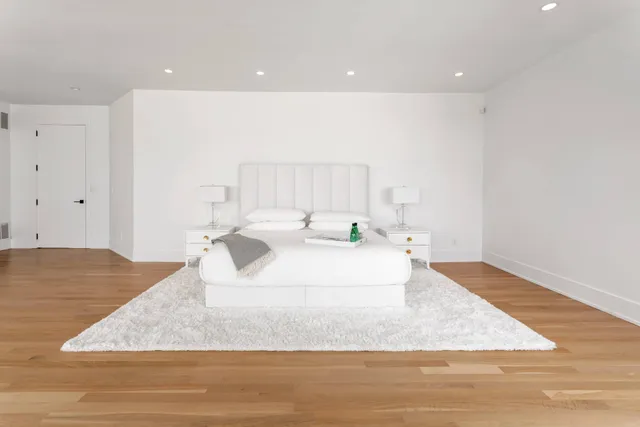 a large white room with kitchen island sink and refrigerator