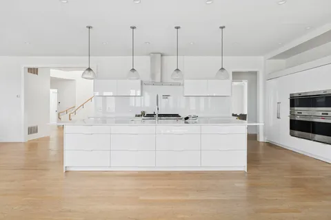 a view of kitchen with stainless steel appliances kitchen island sink stove and living room view