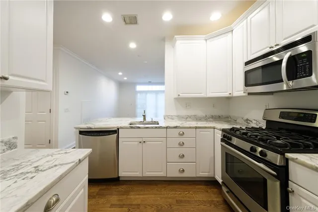 a kitchen with stainless steel appliances granite countertop a stove a sink and a microwave