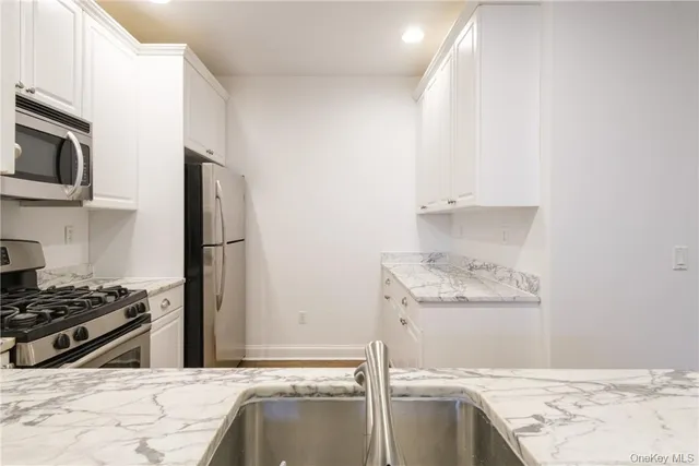 a kitchen with stainless steel appliances granite countertop a refrigerator and a stove top oven